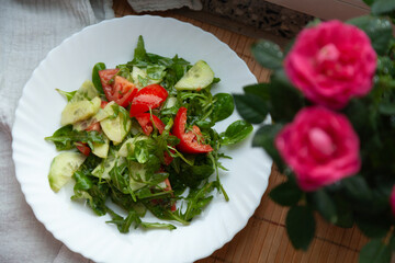 Fresh salad with tomatoes, cucumbers, and arugula.  A healthy and delicious meal.