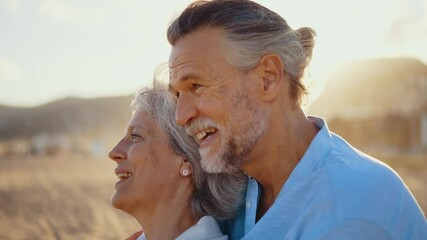 Beautiful happy senior couple dating at the seaside during summertime - Mature married couple in love bonding outdoors at the beach, concepts about elderly lifestyle, relationship and quality of life
