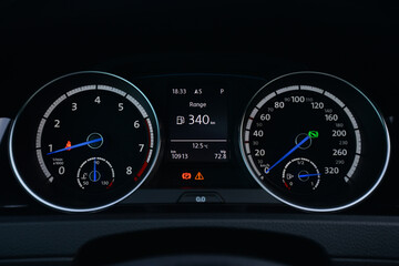 Close up view of a car's instrument panel showing the speedometer tachometer and fuel gauge