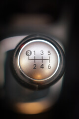 Close up of a six speed manual gear stick in a vehicle The metallic shift knob displays the gear positions clearly
