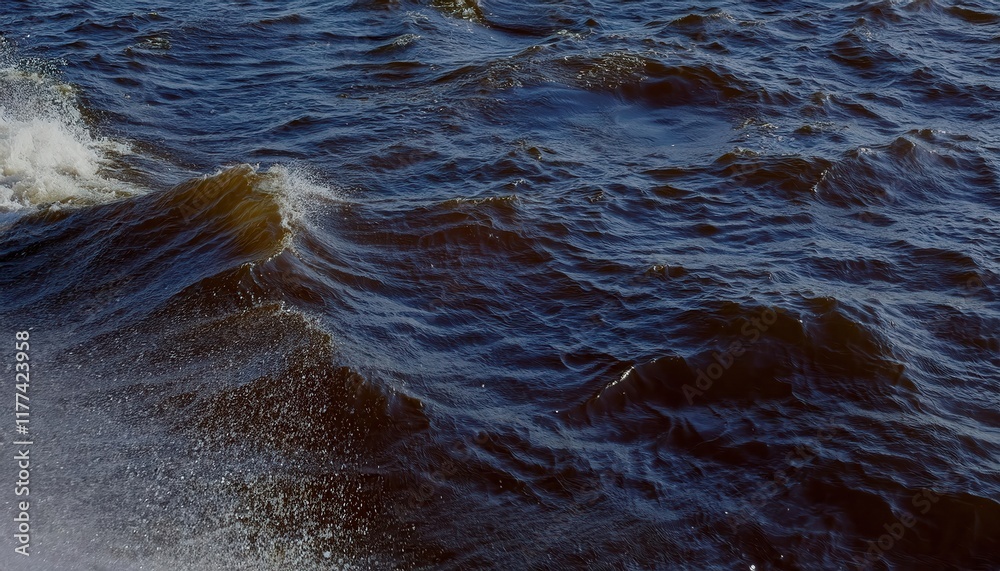 Poster close-up view of gentle brownish waves with sparkling droplets on windy water surface, capturing nat