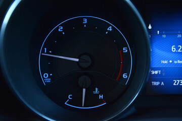 Close up of a car's instrument panel showing the tachometer speedometer and fuel gauge