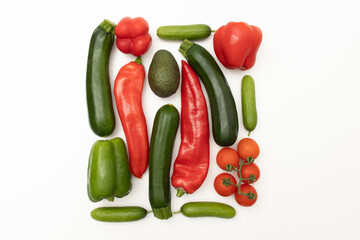 Colorful fresh vegetables including tomatoes, peppers, avocado, eggplant and cucumbers on white background. Top view. Healthy eating. Copy space