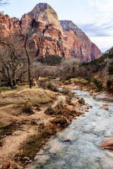 A river flows through a canyon with a mountain in the background