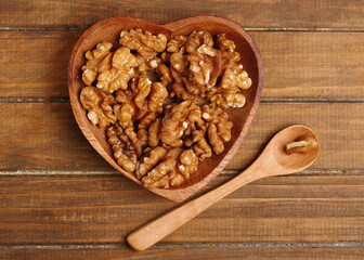 bowl with walnuts on wooden background