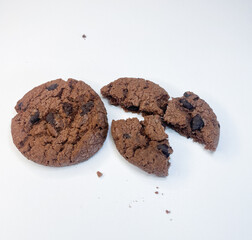 Two chocolate cakes with chips on a white surface. One cake remained intact, while the other broke into several pieces