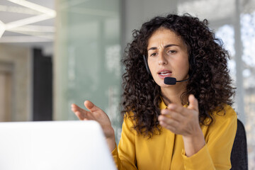 Serious and focused woman with headset talking remotely, close-up of helpline worker working...