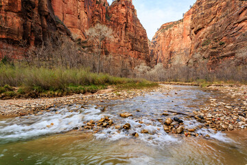 A river flows through a canyon with a rocky shore