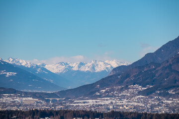 Scenic view on Villach city seen from Taborhoehe in Carinthia, Austria, Europe. Surrounded by snow capped mountains of High Tauern and Gailtal Alps. Alpine Landscape in frosty winter, Austrian Alps