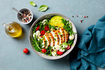 Warm grilled chicken salad with avocado and mozzarella cheese. Close up. Top view.