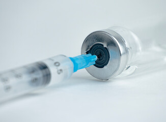A syringe is inserted into a vial