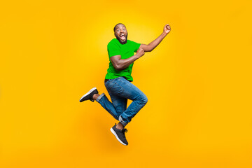 Obraz premium Full length body size photo of black man wearing red t-shirt having caught something invisible and now dragging it while isolated with yellow vivid background