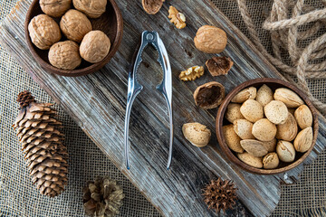 nutcracker for cracking nuts and assorted nuts in a wooden bowls. Top view