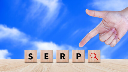 SERP, Search Engine Result Pages concept, magnifying glass and wooden cube with text SERP, can be used for business, marketing and education concept