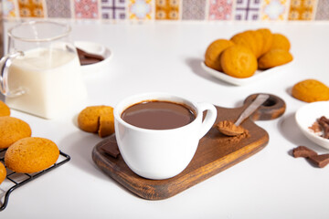 Hot chocolate or coffee espresso with chocolate pieces and cookies.