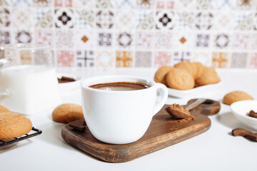 Hot chocolate or coffee espresso with chocolate pieces and cookies.
