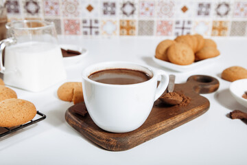 Hot chocolate or coffee espresso with chocolate pieces and cookies.