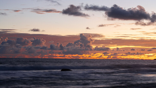 sunset over the tropical beach , orange sky 