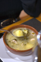  A horizontal shot showcasing a steaming rustic soup served in a clay bowl.