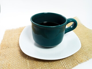 green coffee cup, tea and spoon with white saucer isolated on white background