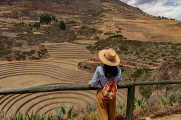 Young Latin tourist visiting Moray; the Inca agricultural laboratory in dry season