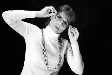 Naklejka premium Frau mit Brille in geneigter Pose als Schwarzweißporträt