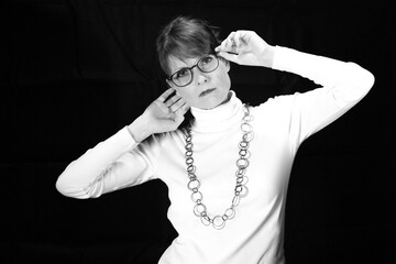 Naklejka premium Frau mit Brille und erhobenen Armen als Schwarzweißporträt