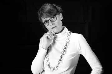 Naklejka premium Frau mit Brille und Hand am Kinn als Schwarzweißporträt