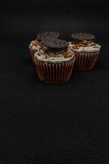 close up of various sweet cupcakes on cake stand isolated on black