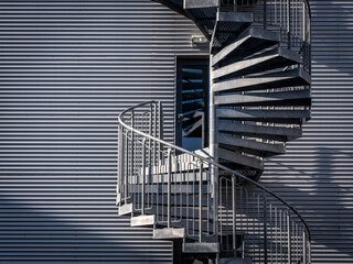 Spiralförmige Feuertreppe aus Stahl an einer Hausfassade