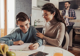 Mother and son doing homework at dining table