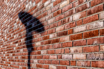 Ziegelwand mit Schatten eines Laternenmastens