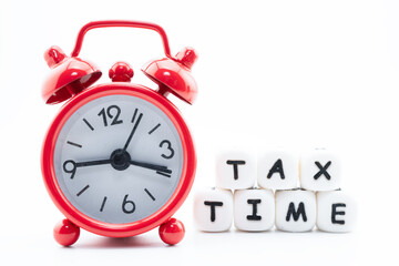 Tax time word with red alarm clock on white background.