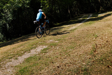 Fototapeta premium A bicyclist rides along a path