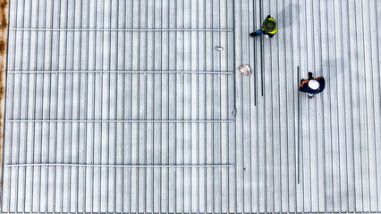 A sustainable energy project featuring solar panels on a roof surrounded by tropical trees,...
