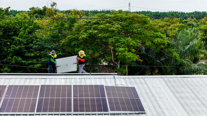 A sustainable energy project featuring solar panels on a roof surrounded by tropical trees,...