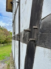 Traditional spruce pin and hole connection of a German half-timbered house with black beams and white walls.