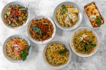 Paris, France - 11 06 2023: Italian culinary Still Life. Seven bowls of pasta seen from above and placed on a wooden table.