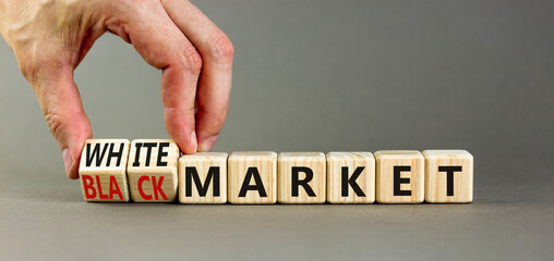 Black or white market symbol. Concept words Black market or White market on beautiful wooden blocks. Beautiful grey background. Businessman hand. Business black or white market concept. Copy space.