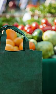 Green Reusable Shopping Bag at a Farmers Market with Blurred Produce