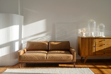 Stylish leather sofa in modern living room with warm lighting and vintage decor