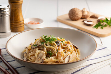 Spaghetti with creamy mushroom sauce,Pasta Linguine with mushrooms and parsley in white plate.Italian traditional dish.