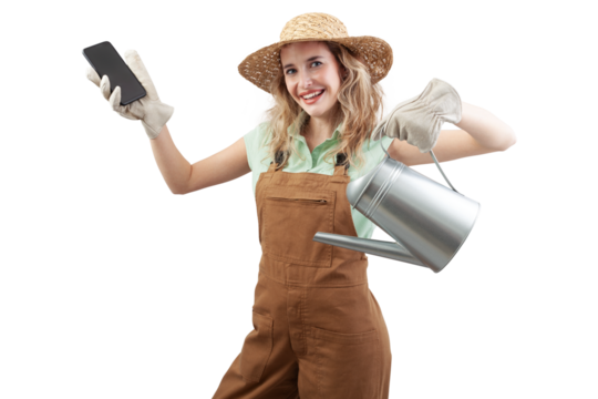 Smiling woman wearing an apron, hat and gloves for gardening holding a watering can, isolated on a white background showing smartphone. Online gardening shopping for spring and garden work