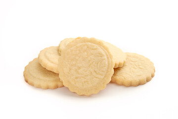 Pile of butter cookies. Multiple round French cookies also known as  Parisian butter cookies, soleils or sablés. Tea biscuit or for holiday gifting. Selective focus. White background.