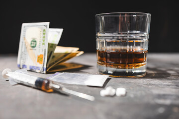 White narcotic pills, an alcoholic drink in a glass, syringe with a dose of heroin, cocaine powder...