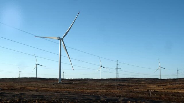 massive propeller blades of wind turbine rotate, generating clean green energy from wind in heart of wilderness. rational use of renewable energy sources in Nordic countries