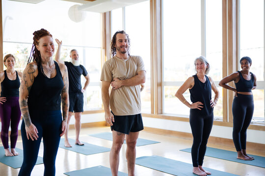 Smiling yoga man in group class.