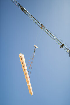Construction crane lifting wooden beams