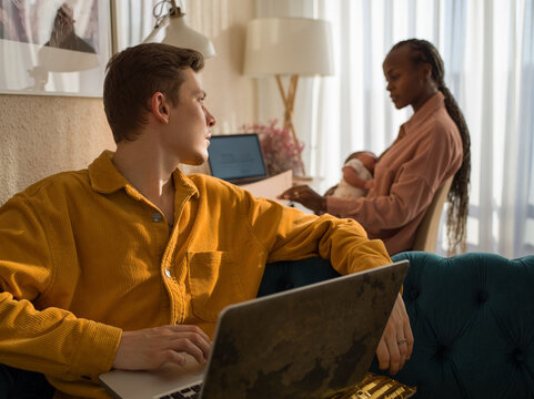 Man working at home with his family on background