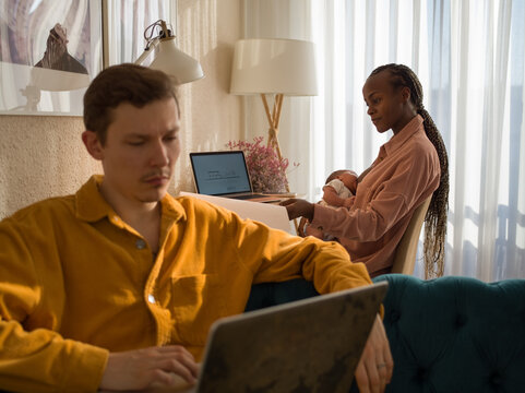 Multitasking woman working and breastfeeding baby